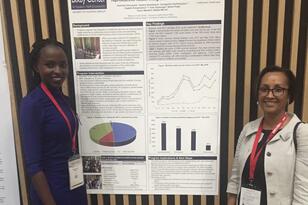 Two women standing in front of academic research poster 