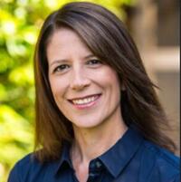 a smiling woman professor wearing a navy blue shirt