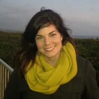 a smiling woman scholar wearing a yellow scarf